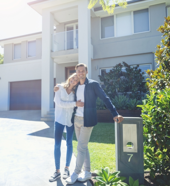 Man and woman standing by house number